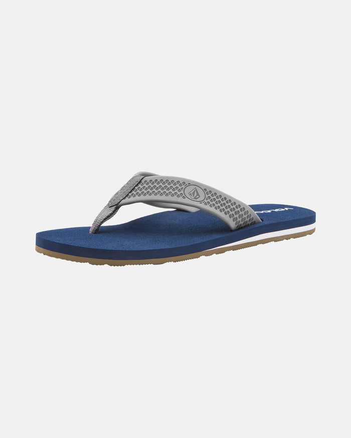 The Volcom Men's Daycation 2 sandal features a textured gray EVA strap, blue molded footbed, and flat sole with a brown rubber outsole for durability, shown individually on a white background.