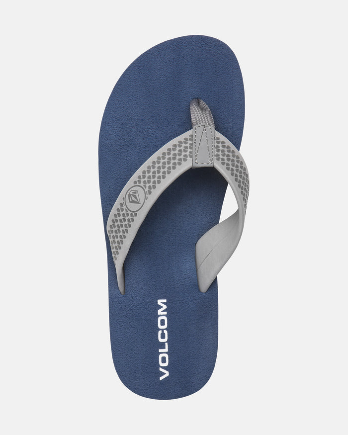 The Volcom Men's Daycation 2 sandal features blue EVA with light gray patterned straps, the Volcom logo, "VOLCOM" printed in white on the molded footbed, and a durable rubber outsole. Shown on a white background.