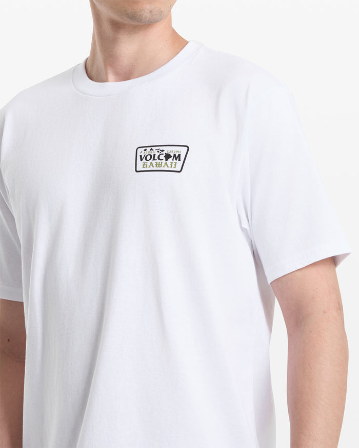 A person wearing the Volcom Men's Dispatch Short Sleeve Tee, featuring a small rectangular Volcom Hawaii logo on the left chest. The photo shows the upper torso and part of the left arm against a white background.
