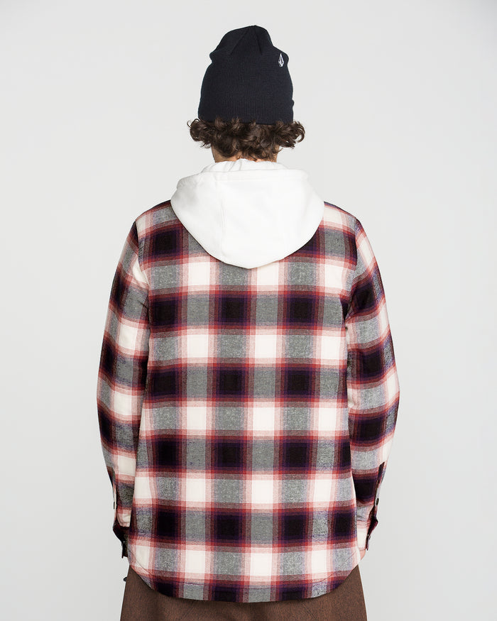A person with curly hair, wearing a black beanie, a Volcom Men’s Enson Insulated Riding Flannel in red, white, and black, and a white fleece hood is facing away from the camera against a plain white background.