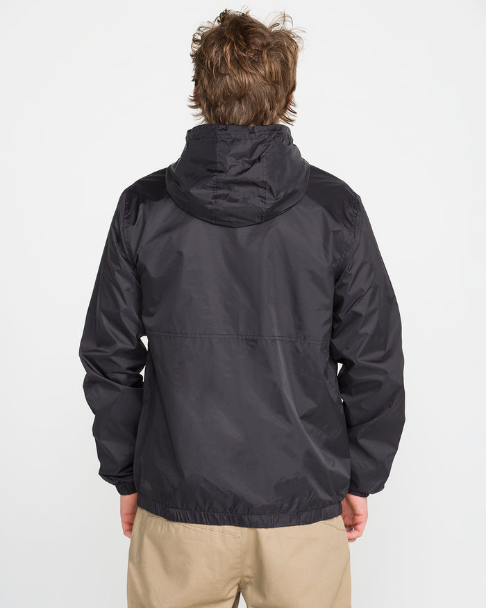 A person with light brown hair is seen from the back, wearing Volcom's Men's Ermont Jacket in black and beige pants, standing against a plain white background.