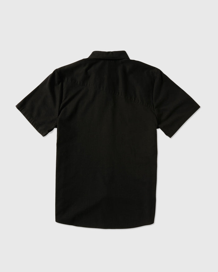 The Volcom Men's Everett Oxford Short Sleeve shirt in black, slim fit, is displayed laid flat with its back and collar shown clearly against a plain light gray background.