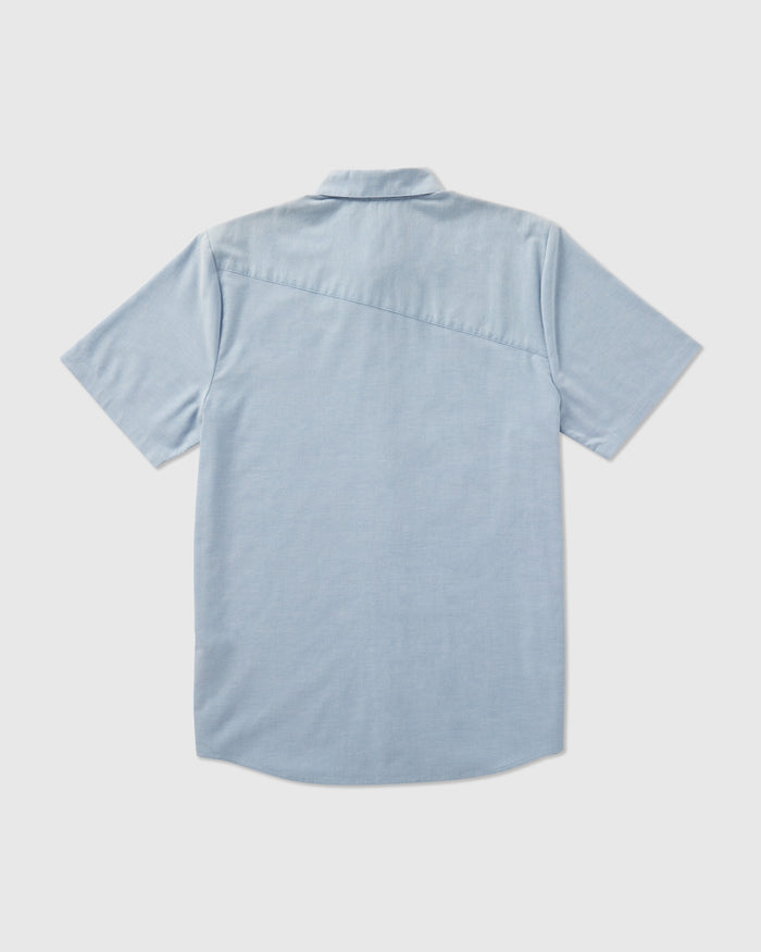 The Volcom Men's Everett Oxford Short Sleeve shirt in light blue has a slim fit, straight hem, and a distinctive diagonal seam across the upper back, combining classic and modern style.
