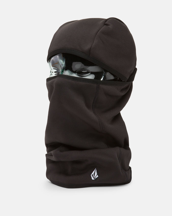 A black Volcom Men’s Face Pow pullover balaclava covers a glass mannequin head, leaving only the eyes exposed. The balaclava features a small white Volcom logo near the bottom edge.