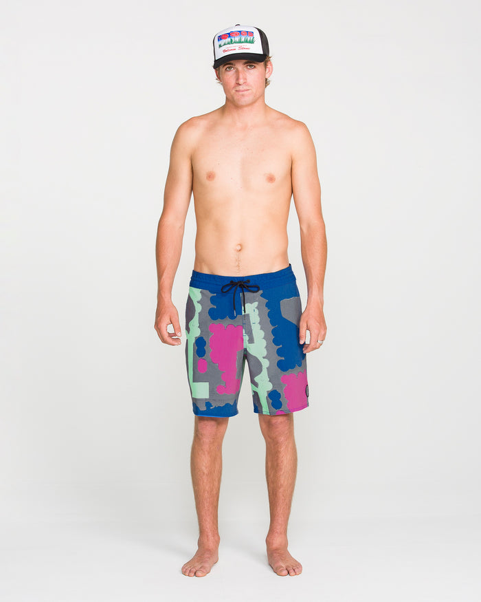 A shirtless person wearing a colorful hat and Volcom Men's Featured Artist Antonio Carrau Stoney Trunks stands facing forward against a plain white background.