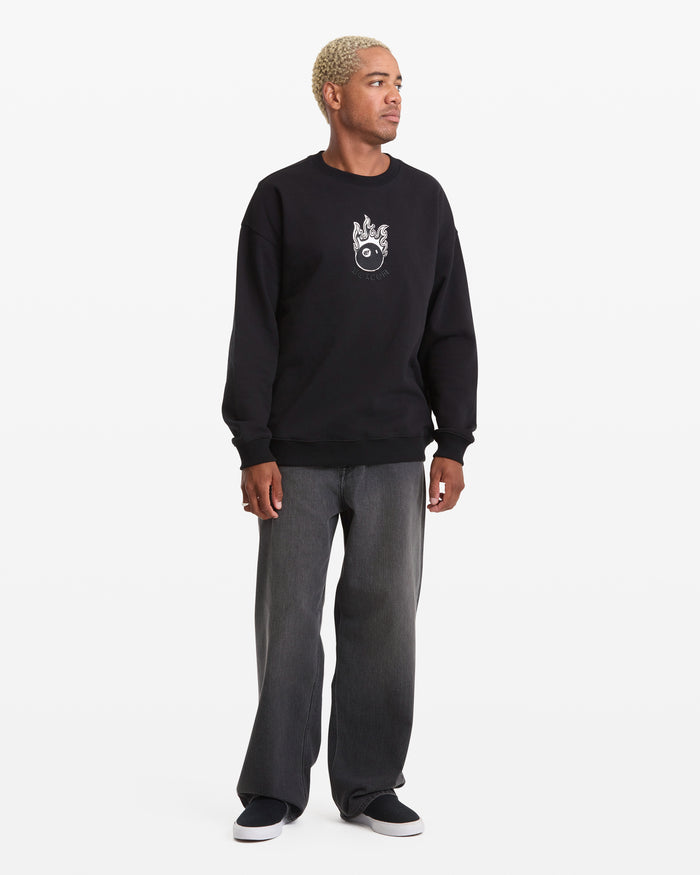 A person with short, bleached hair wears the Volcom Men's Featured Artist Seth Conboy Crew, paired with wide-legged dark jeans and black slip-on shoes, standing against a plain white background.