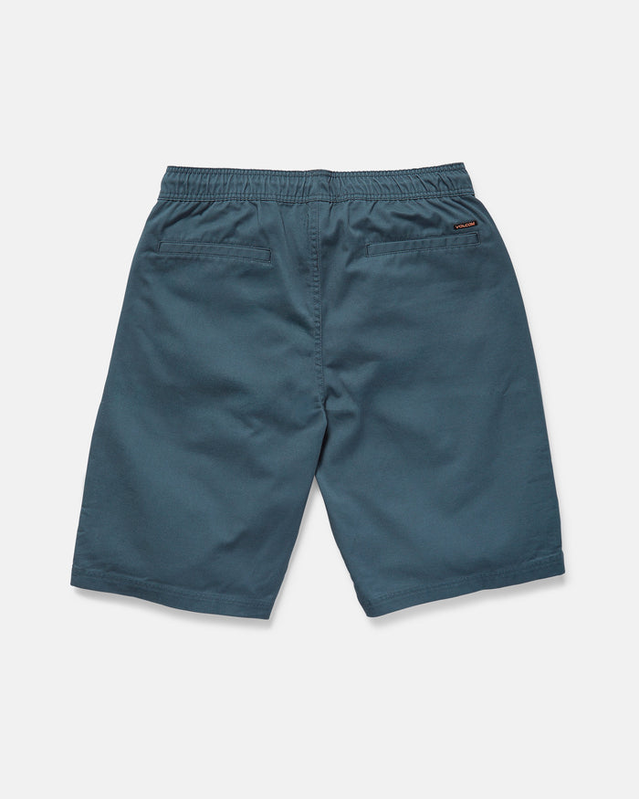 The rear view shows Volcom Men's Freazy Loose Elastic Waist 22" Shorts in blue-green corduroy with a 22-inch outseam, two back welt pockets, and a stitched logo tag on the right pocket against a plain white background.