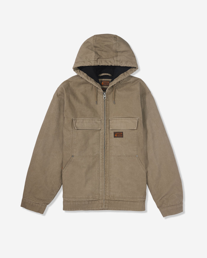 The Volcom Men's Freshdust Workwear Jacket in tan features a zip front, large flap hand and chest pockets, a small rectangular patch on the left chest, and long sleeves. Shown on a white background.