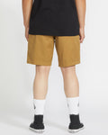 A person stands facing away from the camera wearing a black t-shirt, Volcom Men's Frickin Elastic Waist Shorts, white crew socks, and black sneakers against a plain white background.