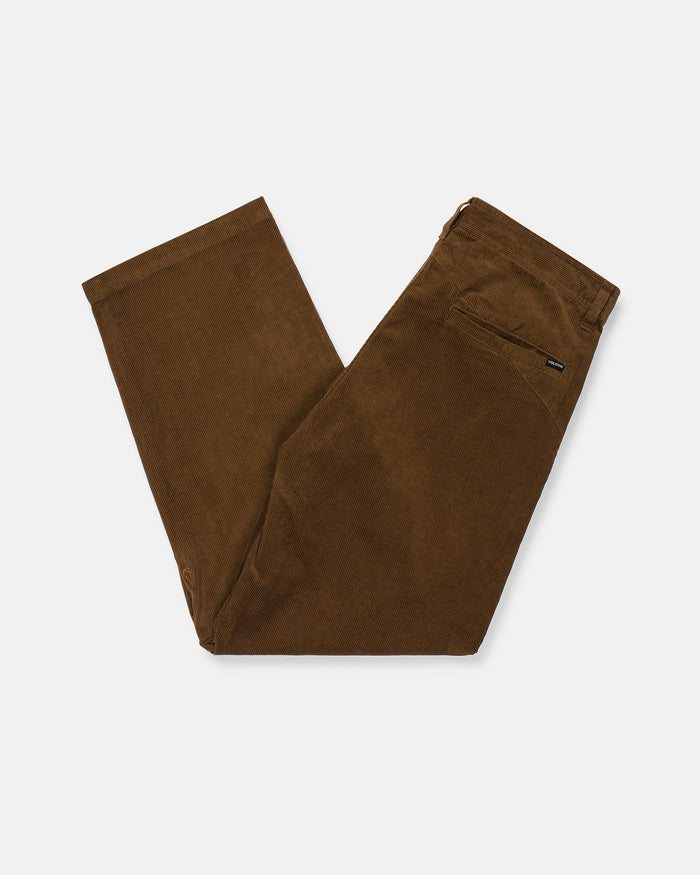 A pair of Volcom Men's Frickin Loose Tapered Cord pants in a rich Desert Palm color, made from 100% cotton corduroy, folded neatly in half on a white background. The pants feature a rear pocket accented with a small black label on the pocket seam.