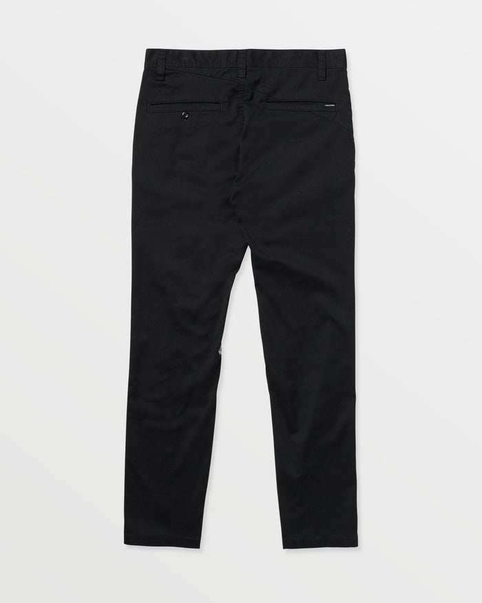 The Volcom Men's Frickin Modern Stretch Pants are black chinos shown laid flat on a white background, back view, featuring two rear pockets and belt loops, crafted with REPREVE recycled fibers for eco-friendly comfort.