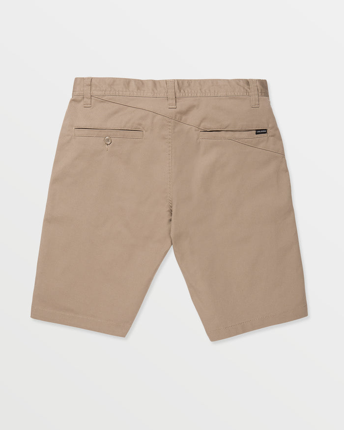 Back view of Volcom Men's Frickin Modern Stretch 21" Shorts in tan chino, featuring belt loops, two back pockets (one with a button), and a black tag above the right pocket, laid flat on a white background.