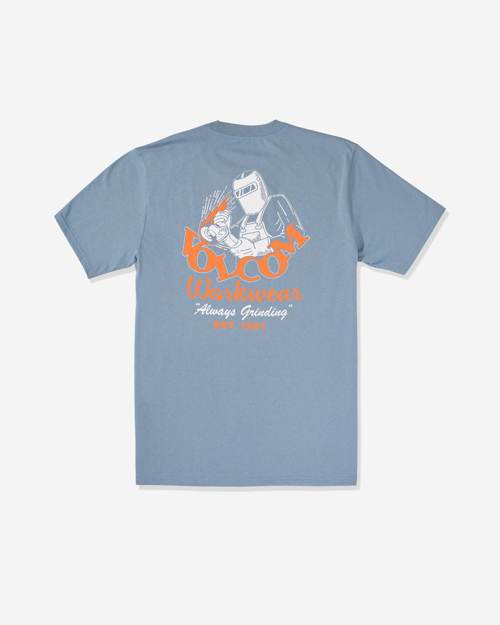 The Volcom Men's Grindit Short Sleeve Tee is a 100% cotton blue shirt with a back graphic of a welder and sparks, plus bold "Volcom Workwear Always Grinding" text in orange and white.