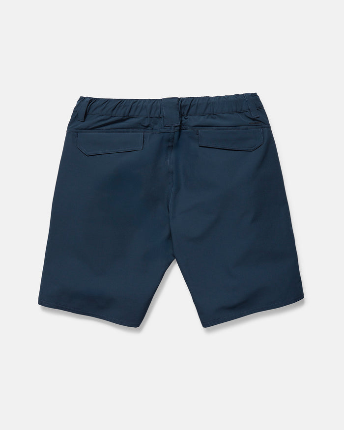 The Volcom Men's Harbor Hybrid Shorts in navy blue are shown from the back, laid flat on a white background. They feature an elastic waistband, two back flap pockets, and a 20-inch outseam.