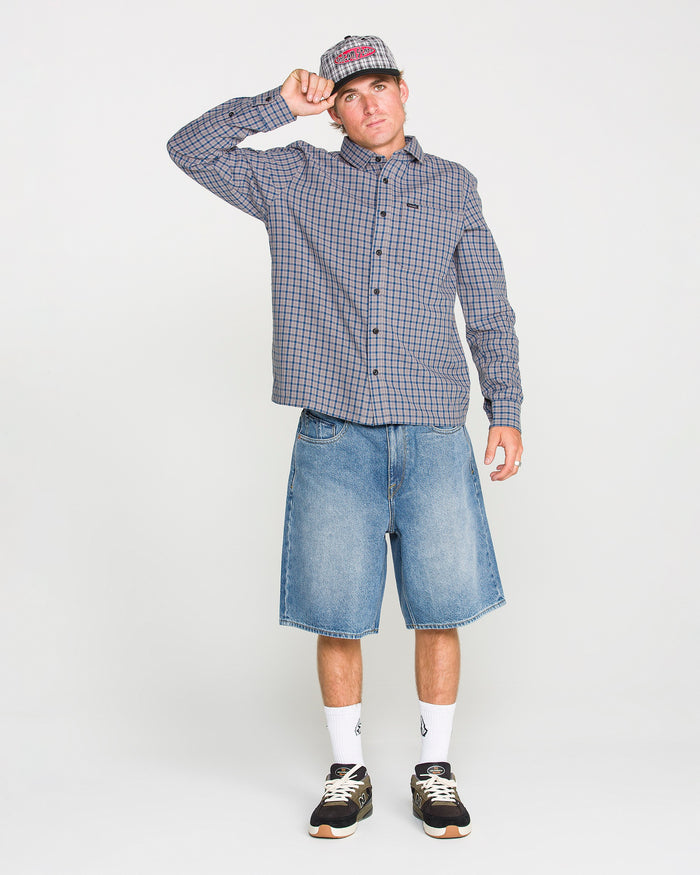 A man wearing the Volcom Men's Landos Long Sleeve Shirt poses against a plain white background.