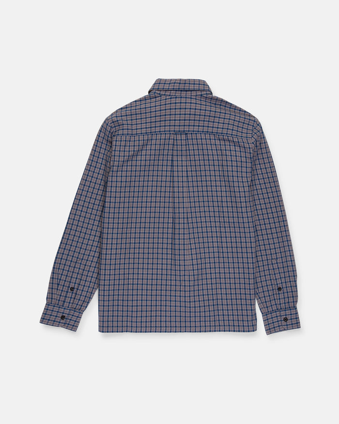 The Volcom Men's Landos Long Sleeve Shirt is displayed from the back on a white background, showcasing its blue and red plaid pattern. This shirt features an oversized chest pocket, buttoned closure, and a relaxed boxy silhouette.