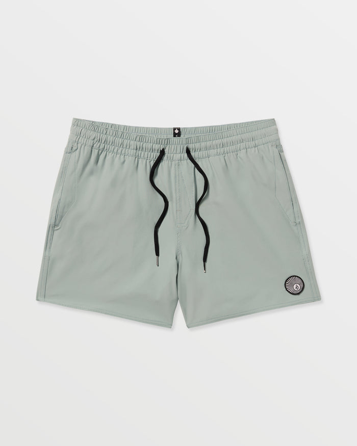 Volcom Men's Lido Solid 16" Trunks in light gray feature a black drawstring, two side pockets, and a small circular patch near the left hem. Made from recycled polyester with 2-way stretch, shown on a plain white background.