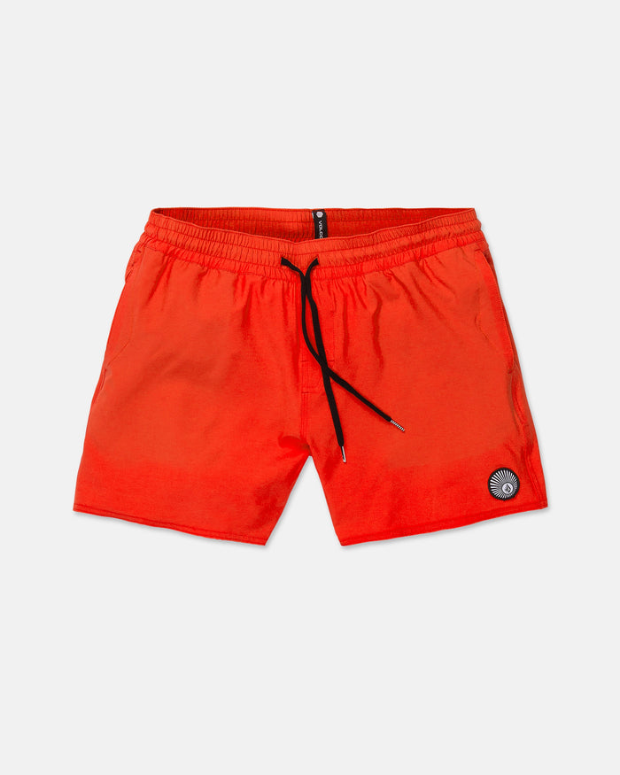 Men's Lido Solid Trunks by Volcom in bright orange, featuring a 16-inch outseam, adjustable drawstring waist, and side pockets. Crafted from recycled polyester, these trunks are finished with a small black and white circular patch on the lower left leg and are shown laid flat against a white background.