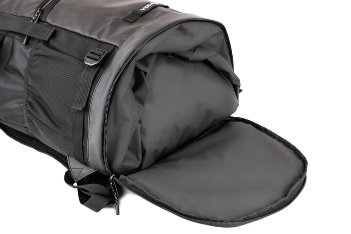 A black Volcom Men's Litestone Gear Pack duffel bag is shown with its end compartment open, revealing a spacious, empty interior. The bag features handles, straps, visible stitching, and organized storage for essentials.