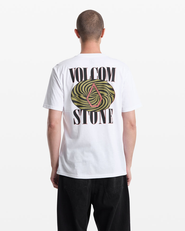 A person is seen from the back wearing Volcom’s Men's Mindsign Short Sleeve Tee, a slim fit, all-cotton shirt with "VOLCOM STONE" in large black letters and a colorful abstract logo, paired with black pants—great for everyday wear.
