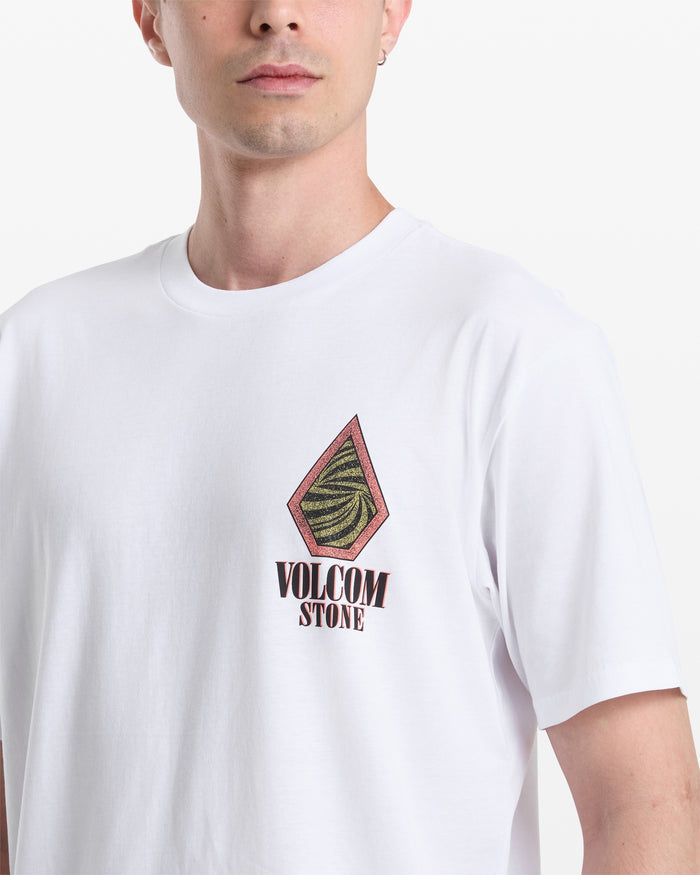 Wearing the Volcom Men's Mindsign Short Sleeve Tee in white, featuring a slim fit, colorful geometric logo, and "VOLCOM STONE" on the left chest. Only part of his face is visible as he faces forward.