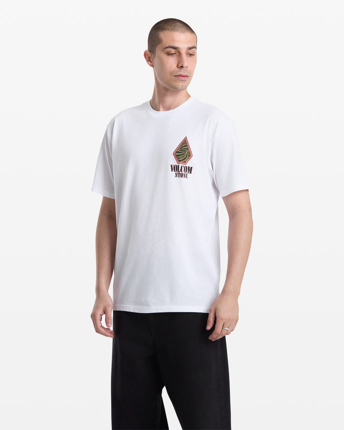 A man wears the Volcom Men's Mindsign Short Sleeve Tee, a slim fit all-cotton shirt with a colorful graphic and VOLCOM STONE text on the left chest, paired with black pants and standing against a plain white background—ideal for everyday wear.