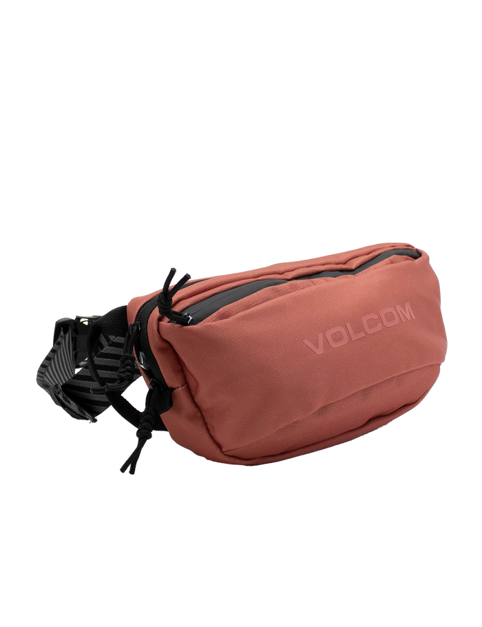 A dusty rose Volcom Men’s Mini Dos Waist Pack featuring a zippered main compartment and an adjustable black strap, shown against a plain white background.