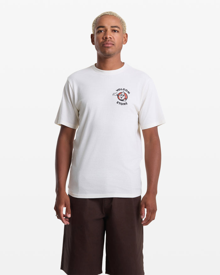 A person faces forward against a white background, wearing the Volcom Men's Mister Stone Short Sleeve Tee in white, featuring a small left-chest graphic and text, paired with dark brown shorts.