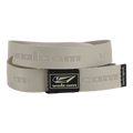 The Volcom Men's Modstone Web Belt in beige is shown coiled, featuring an embossed Volcom logo and a black rectangular metal clamp buckle with the Volcom logo in white.