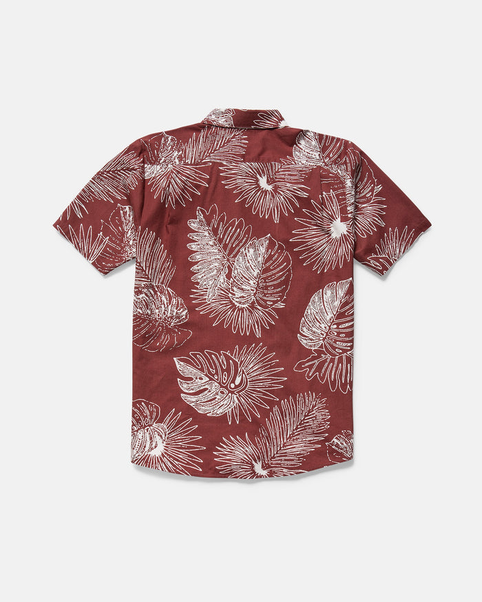 The Volcom Men's Monsterious Short Sleeve Shirt features an all-over white tropical leaf print on maroon, made from a soft cotton-viscose blend, shown laid flat with the back facing up.