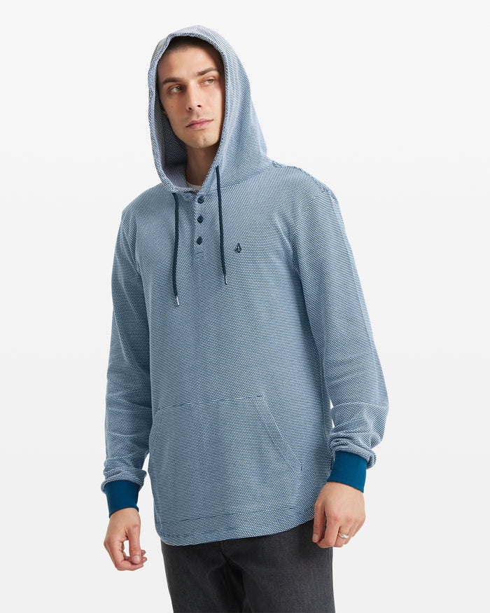 A person wearing the Volcom Men's Murph Thermal Long Sleeve in light blue and black pants stands against a plain white background.