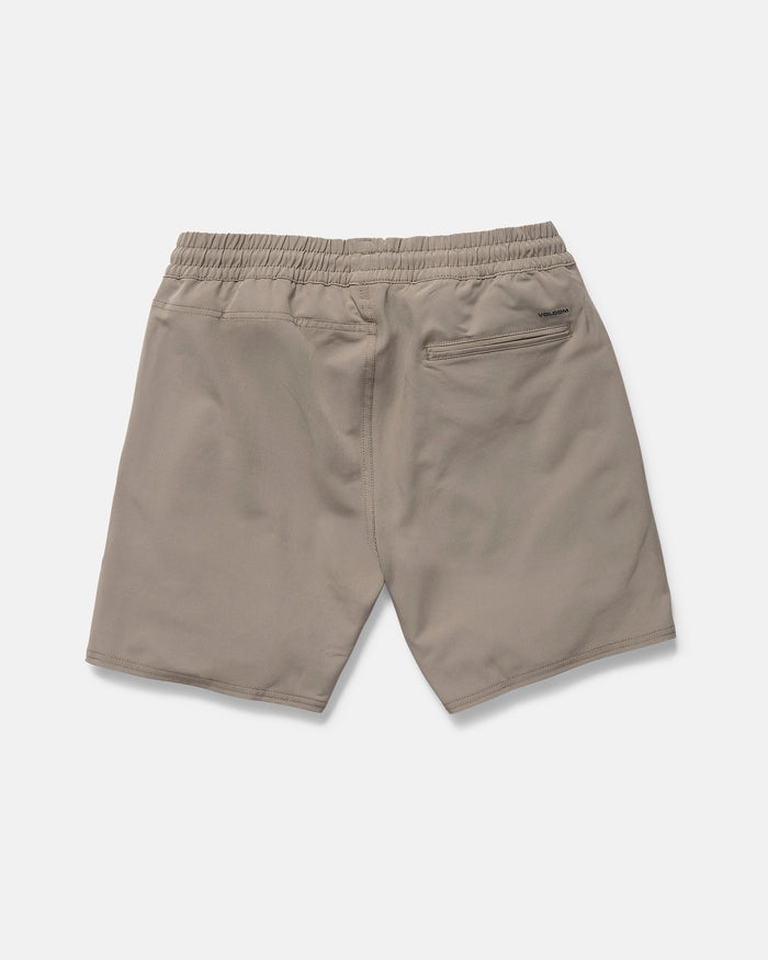 The Volcom Men's Nomoly Elastic Waist Shorts 18" in khaki are made from recycled polyester with 4-way stretch, featuring two side pockets and a zippered back pocket. Shown laid flat from the back on a white background.