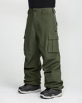 A person stands against a plain white background wearing the Volcom Men’s Nwrk 20K Baggy Pants in olive green and black snow boots; these men’s snow pants feature a 20K waterproof finish.
