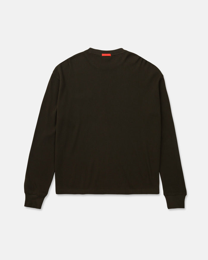 The Men's Overtime Workwear Thermal Long Sleeve Shirt by Volcom is shown from the back in plain black, featuring ribbed cuffs, a small red tag at the neckline, and crafted from comfortable cotton waffle thermal fabric—making it an ideal staple for everyday workwear.
