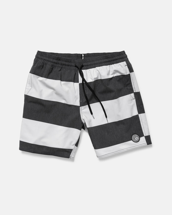 The Volcom Men's Psyche Cotton 17" Trunk features wide black and white stripes, an elastic waistband with black drawstring, side pockets, a logo on the left leg, and a classic 17-inch outseam.