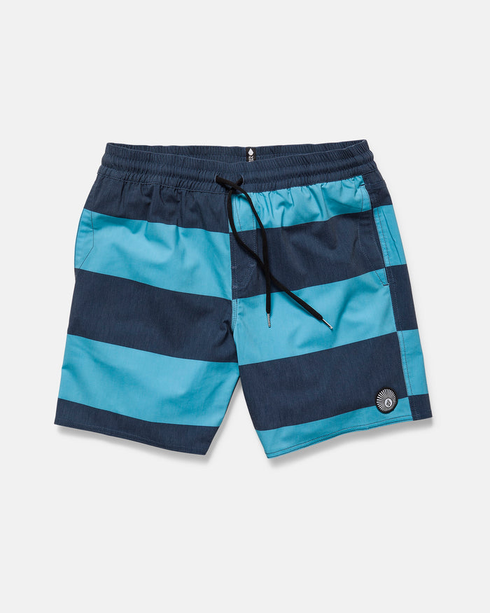 The Volcom Men's Psyche Cotton 17" Trunk features blue and navy stripes, an elastic waistband with black drawstring, side pocket, and a circular logo patch near the left hem, shown against a white background.