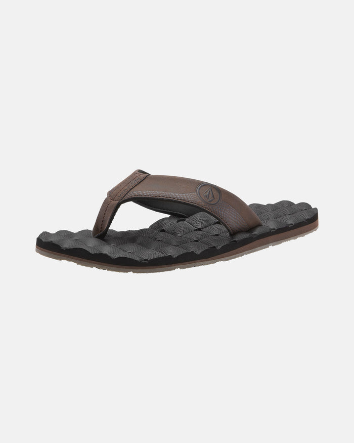 A single Volcom Men's Recliner flip-flop, featuring a brown strap and black woven-texture sole with extra grip, is displayed against a plain white background.