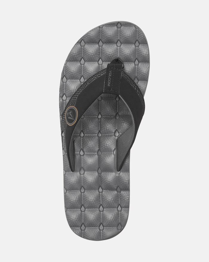 The Volcom Men's Recliner is a gray and black flip-flop featuring a textured footbed and black fabric strap with a small circular logo—ideal for anyone seeking cushy sandal comfort.