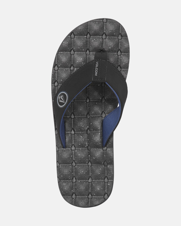 A single black Volcom Men's Recliner flip-flop with an extra-grippy, geometric-patterned footbed and a Volcom logo on the strap, shown from above on a white background.