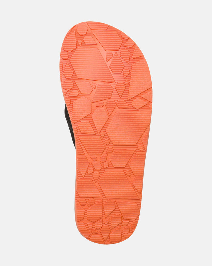 The Volcom Men's Recliner sandal features an orange sole with a geometric textured pattern, shown from the bottom against a white background. The cushy side strap is partially visible, emphasizing comfort and style.