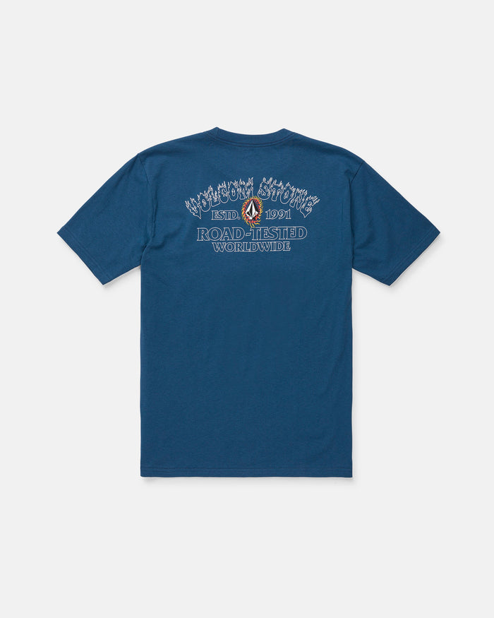 The Volcom Men's Ringafire Short Sleeve Tee, shown from the back in blue, is crafted from premium ring spun cotton for a soft, durable feel. This heavy-weight t-shirt features decorative white and blue "Road-Tested Worldwide" text, a small graphic, and additional branding above and below it.