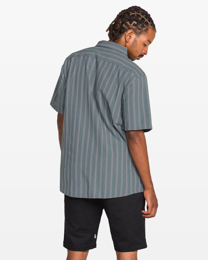 Man wearing a striped shirt and black shorts on a white background