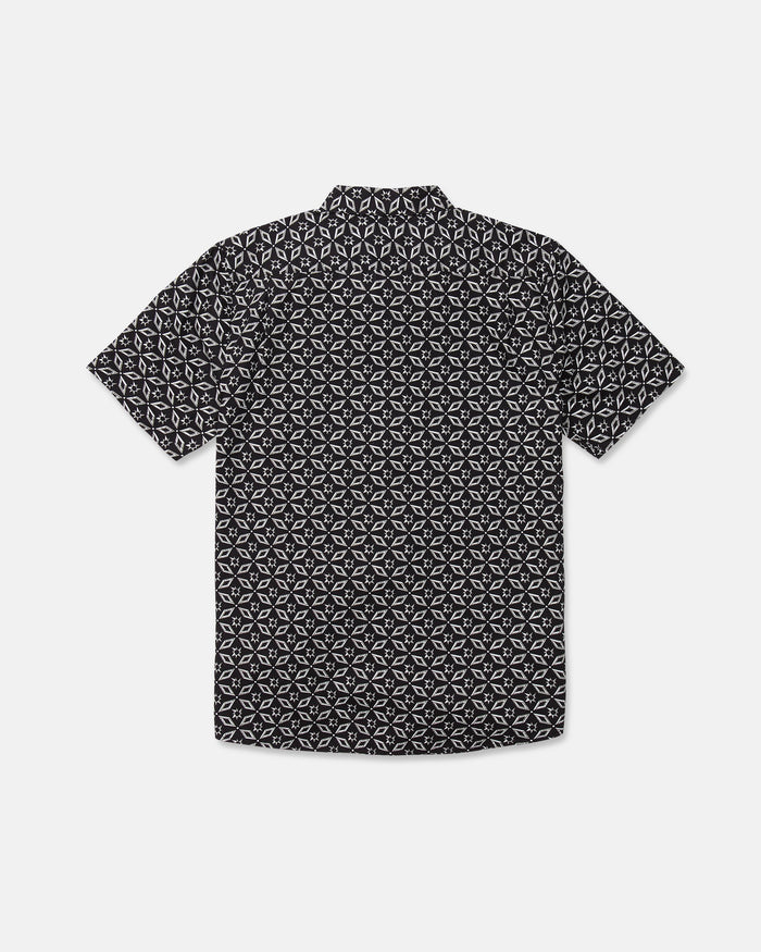 The Volcom Men's Scaler Stone Short Sleeve Shirt, featuring a black background with a white geometric pattern, is shown from the back.