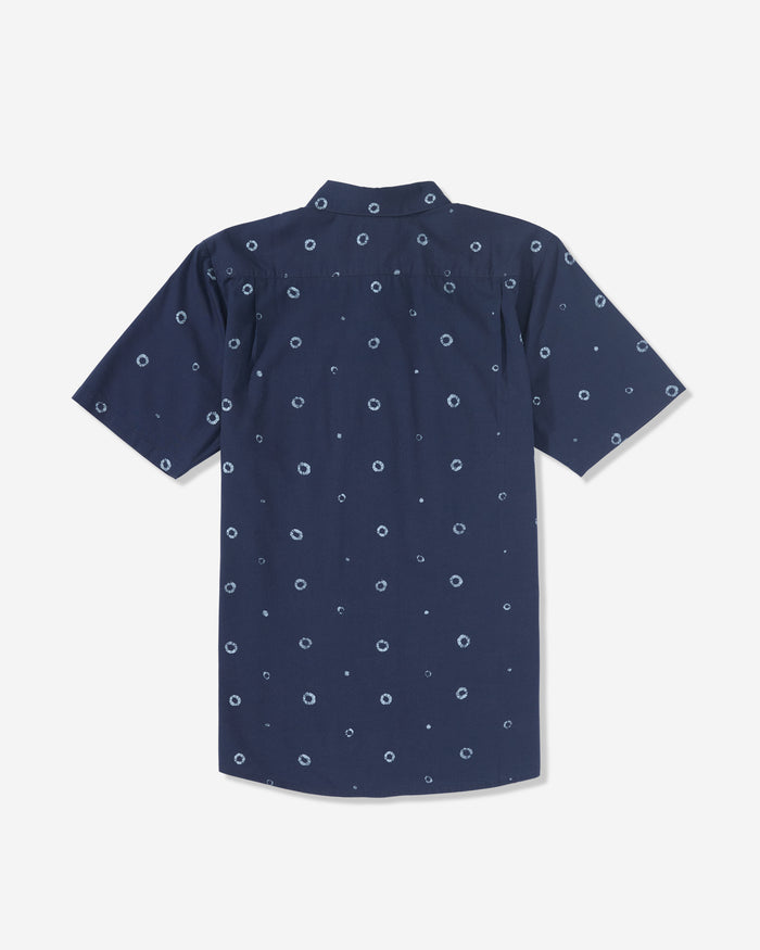 The Men’s Scaler Stone Woven Short Sleeve Shirt by Volcom is a navy blue collared shirt with an allover print of small white circular dots, shown from the back.