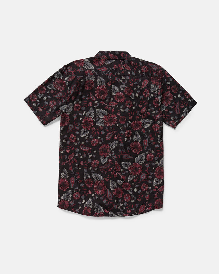 The Volcom Men's Scaler Stone Woven Short Sleeve Shirt features a black base with an all-over red, gray, and white floral pattern. This classic fit button-up is shown laid flat with the back side facing up.