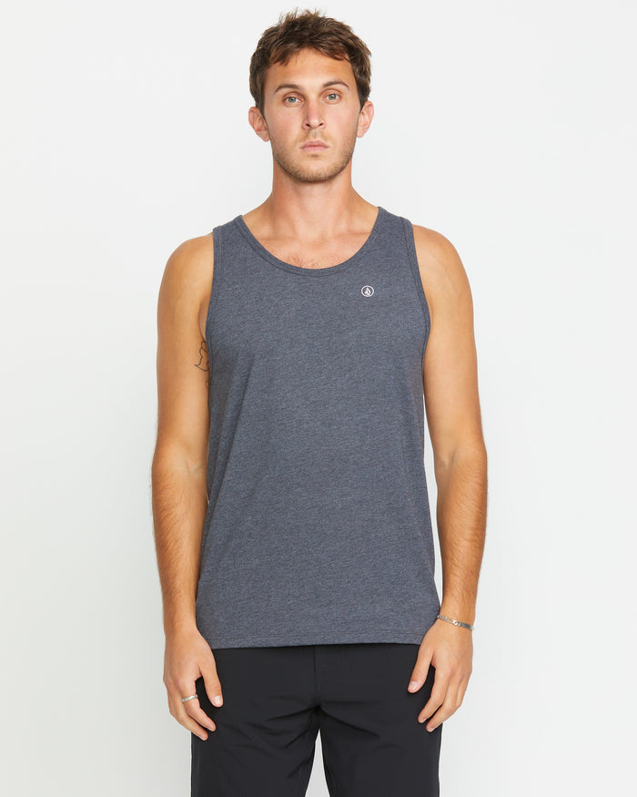 A man with short brown hair wears the Volcom Men's Solid Heather Tank in a modern fit with black pants, standing facing forward against a plain white background.