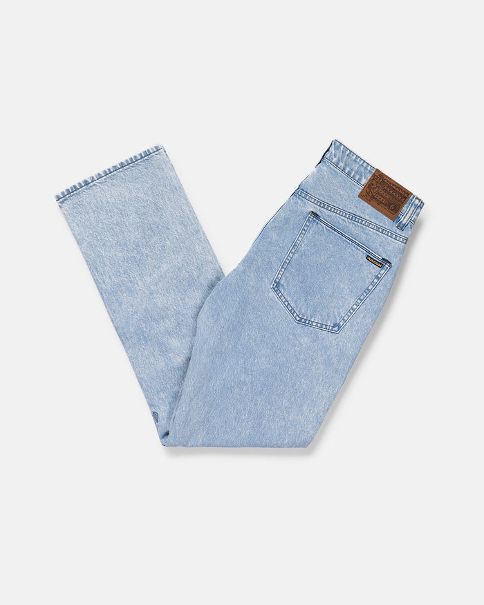 Men's Solver Denim Pants by Volcom in light blue, straight leg, shown folded in half on a white background with visible back pocket, waistband, belt loops, and a brown leather Volcom brand patch above the pocket.