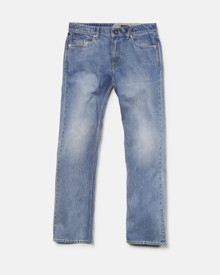 A pair of Volcom Men's Solver Denim Pants in Freedom Blue, featuring a modern straight leg cut, crafted from soft stretch denim with front pockets, belt loops, and a button closure, laid flat on a white background.