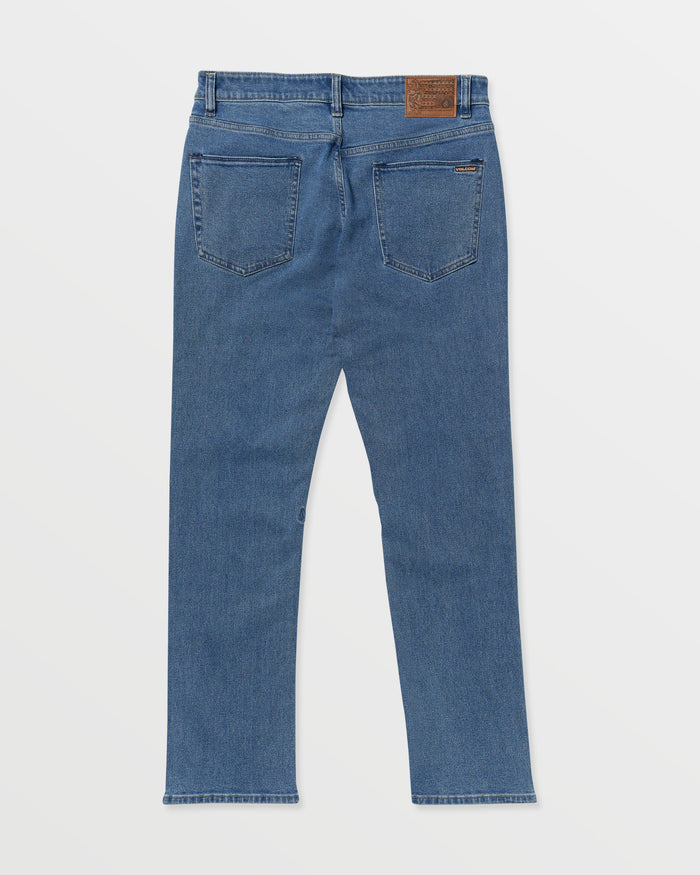 A pair of Men's Solver Denim jeans in blue, shown from the back with two rear pockets and a brown leather waistband patch, are laid flat on a white background.