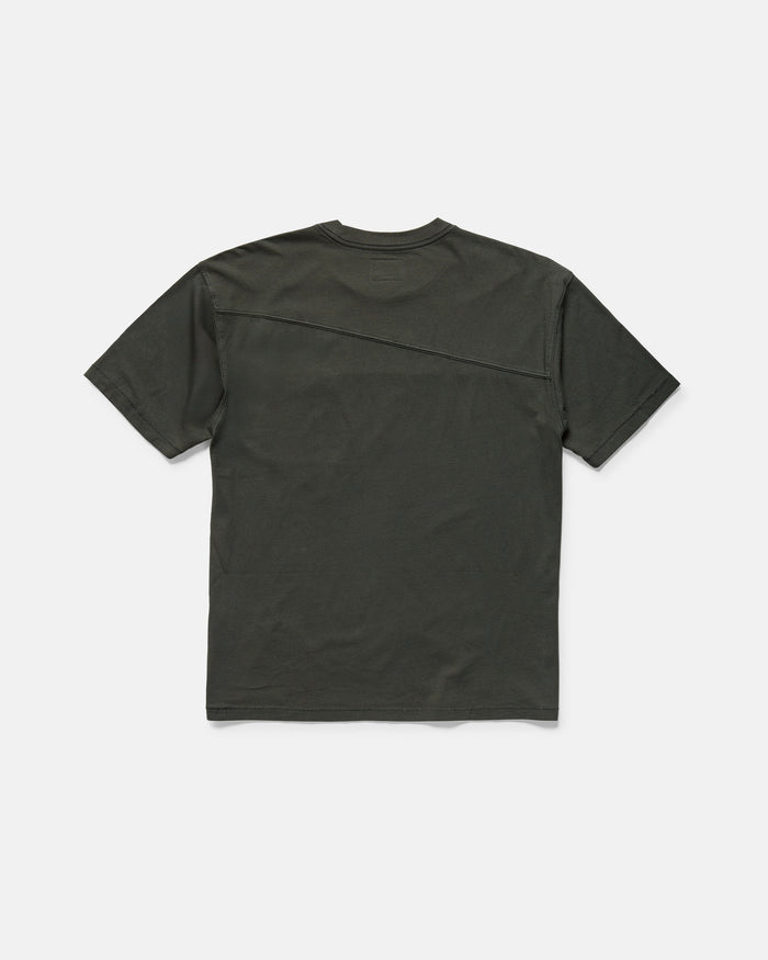 The Volcom Men's Stone Cruiser Crew is a plain, dark green short-sleeve t-shirt laid flat and viewed from the back. Made from 100% cotton jersey, it features a subtle diagonal seam from the right shoulder to the left side.